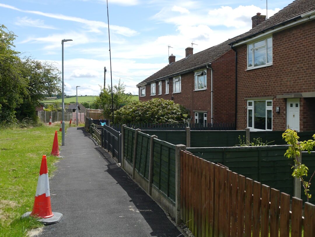 Neighbors chatting over a garden fence in a residential street